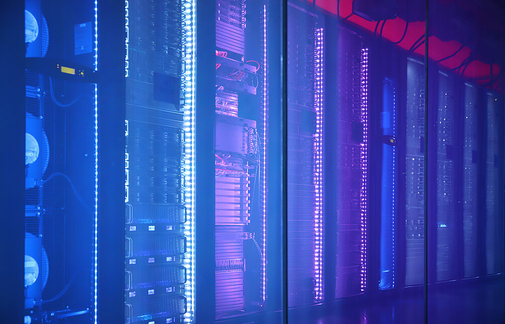 TERRA CLOUD Cube Reihe von Serverracks in einem Rechenzentrum, beleuchtet mit blauem und violettem LED-Licht hinter einer Glaswand